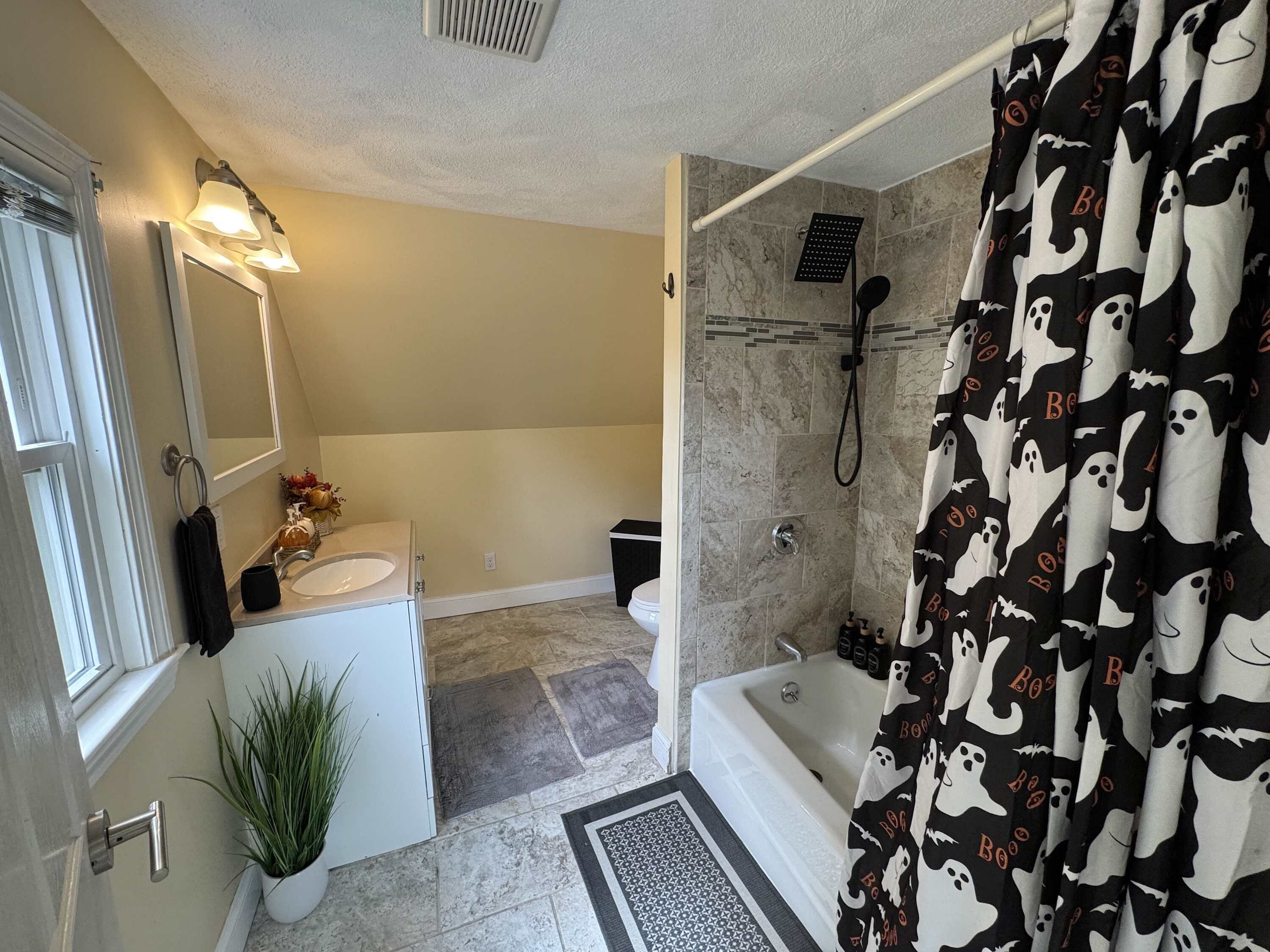 Une salle de bain avec une baignoire, une douche et des toilettes.