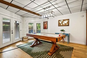 Una habitación con mesa de billar, techo de madera y un mapa del mundo en la pared.