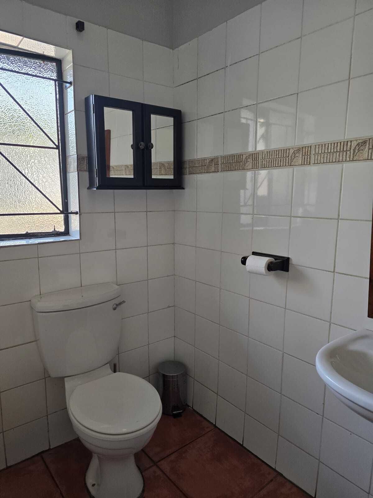 Un baño pequeño con inodoro, lavamanos y ventana.
