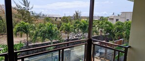 Ein Balkon mit Blick auf einen Garten und Gebäude.