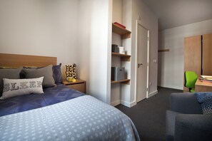 A bedroom with a bed, bedside table, lamp, and a wardrobe. - Student Only Algernon Firth (Leeds)