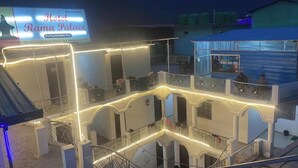 A hotel with a traditional architectural style, featuring multiple balconies and a central courtyard. - Hotel Rama Palace (Ukhimath)