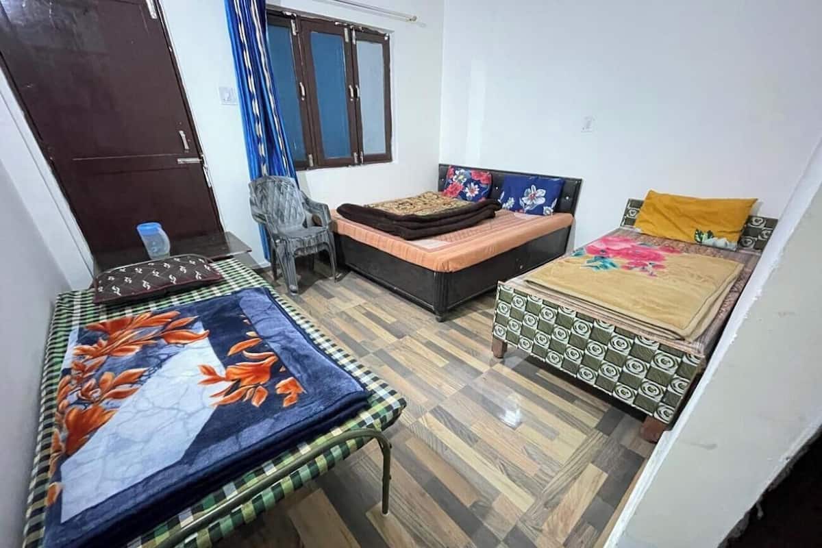 A room with two beds, a sofa, and a small table.