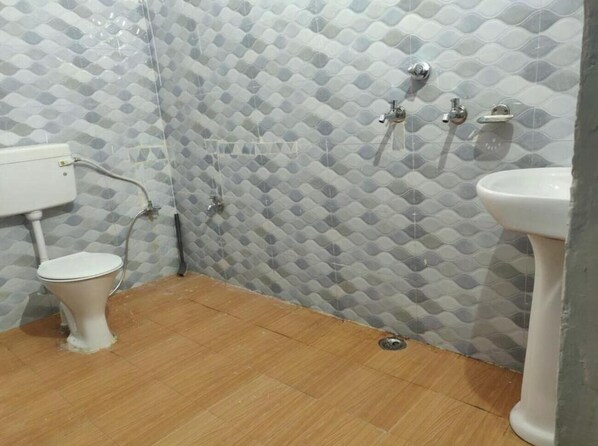 A bathroom with a toilet, sink, and shower.