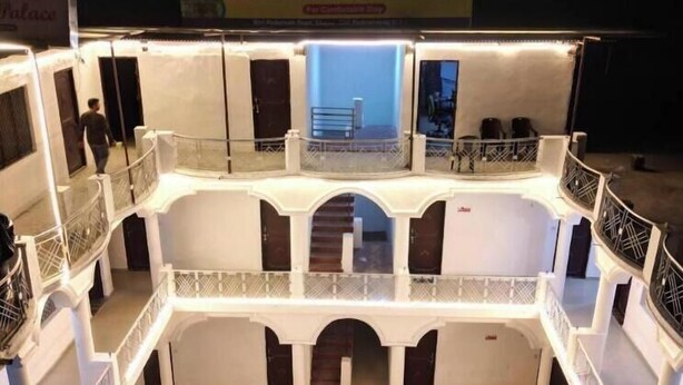 A multi-level hotel structure with balconies and railings, a sign reading "HOTEL RAMA PALACE," and a staircase leading to the upper levels. - Hotel Rama Palace (Ukhimath)