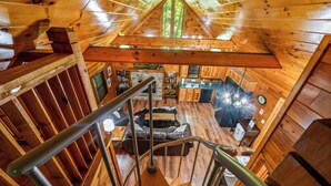L’intérieur d’une cabane en bois comprend une chambre à coucher située en mezzanine, un coin repas et une cuisine.