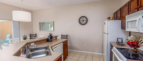 A modern kitchen with a central island, stainless steel appliances, and wooden cabinets.