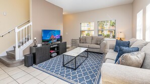 A living room with a TV, sofa, and coffee table. - 101 Perfect Family Townhouse With Private Pool Near Disney Water Parks (Kissimmee)