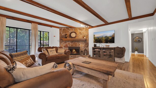 Un salón espacioso con chimenea de piedra, un televisor grande y una zona de estar acogedora.