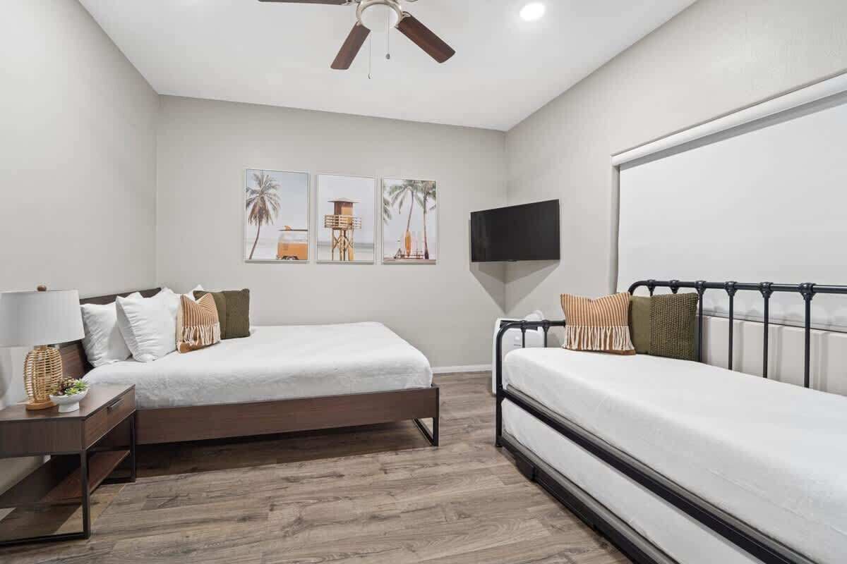 A bedroom with a bed, bedside table, lamp, and a TV.