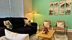 A living room with a sofa, two armchairs, a coffee table, and a lamp. - Well-Equipped 2BR Unit with Parking (Evanston)
