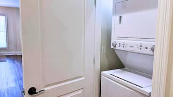 A laundry room with a door, a washing machine, and a dryer.