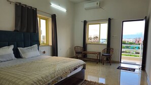 Quarto com cama, janela, cadeira e mesa.