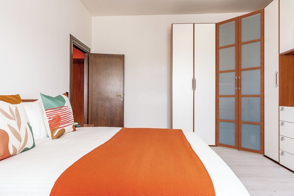 A bedroom with a bed, pillows, a wardrobe, and a door. - Detached cottage in the green, ideal for families and those seeking relaxation and privacy (Cecchina)