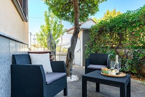 An outdoor seating area with wicker furniture and a table set with bread and wine glasses. - Detached cottage in the green, ideal for families and those seeking relaxation and privacy (Cecchina)