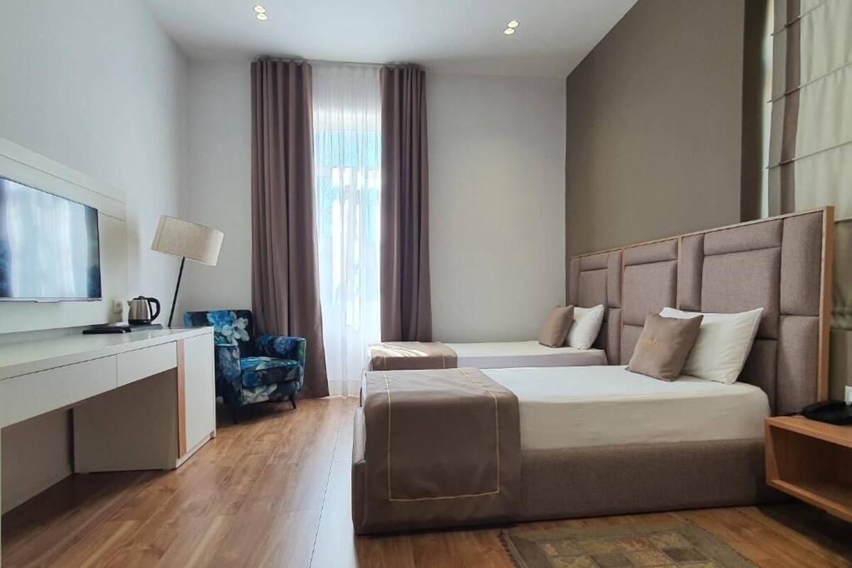 Habitación de hotel moderna con una cama grande, un escritorio, una silla y un televisor.