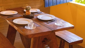 A wooden dining table with benches, plates, and cutlery. - Casa Amarela em Icaraí de Amontada (Amontada)
