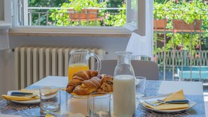 A breakfast table with croissants, a jug of orange juice, and a glass of milk. - Elegant 2 Suites Residence,city centre,near Famous Castrocaro Thermal Baths (Castrocaro Terme)