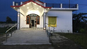 A building with a red roof, a sign reading "SHUKRANA," and a staircase leading to the entrance. - Wilder Lust Homestay (Bhira)