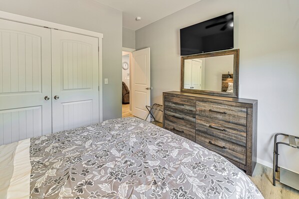A bedroom with a bed, a dresser, a mirror, and a TV. - 2 Mi to Marina & Lake Cumberland! Newly Built Home (Somerset)