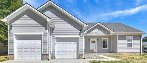 A two-story house with a garage, a front door, and a small porch.