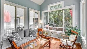 A spacious living room with a sofa, rocking chair, and a glass coffee table. - 30 Acres & Pond: North Georgia Mtn Farmhouse (Demorest)