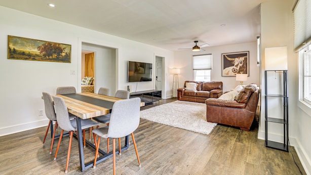 A spacious living room with a dining area, a leather sofa, a TV, and artwork on the walls. - Families Welcome, Fenced Yard: Inviting Greer Home (Greer)