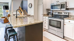 A modern kitchen with granite countertops, stainless steel appliances, and a central island with bar stools. - 4 MI to Lake Galena: TH w/ Indoor Pool & Views! (Galena)