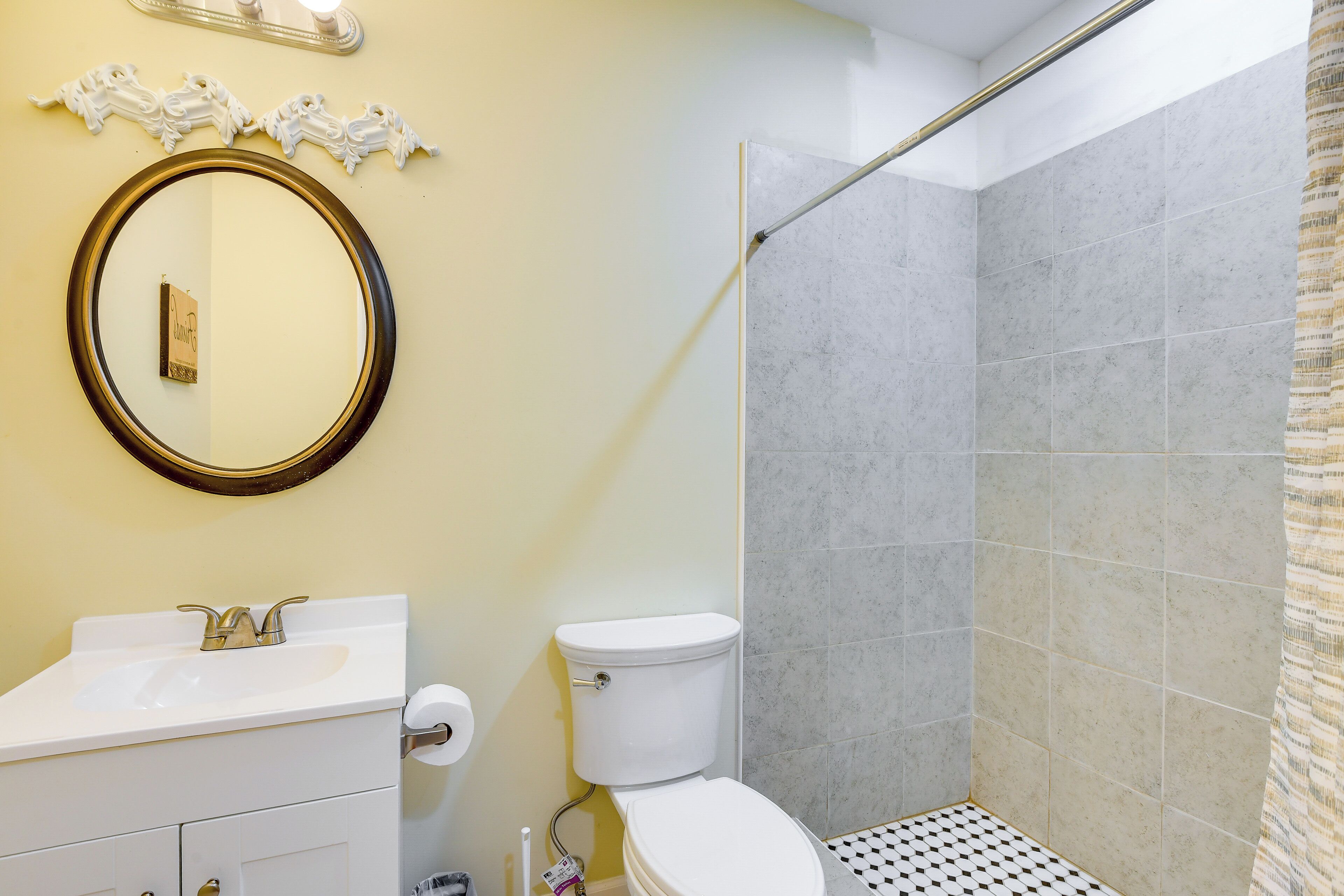 A bathroom with a toilet, sink, and shower.