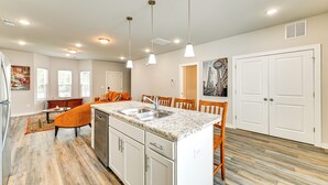 A modern kitchen with granite countertops, stainless steel appliances, and pendant lighting.