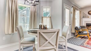 A dining area with a round table, four chairs, and a chandelier. - 1 Mi to Zoo: 'rustic Bungalow' in Gulf Breeze! (Gulf Breeze)