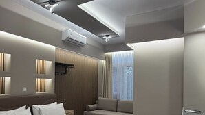 A modern bedroom with a bed, a sofa, and a ceiling fan. - Monastiraki 110 Superhost Hub (Athens)