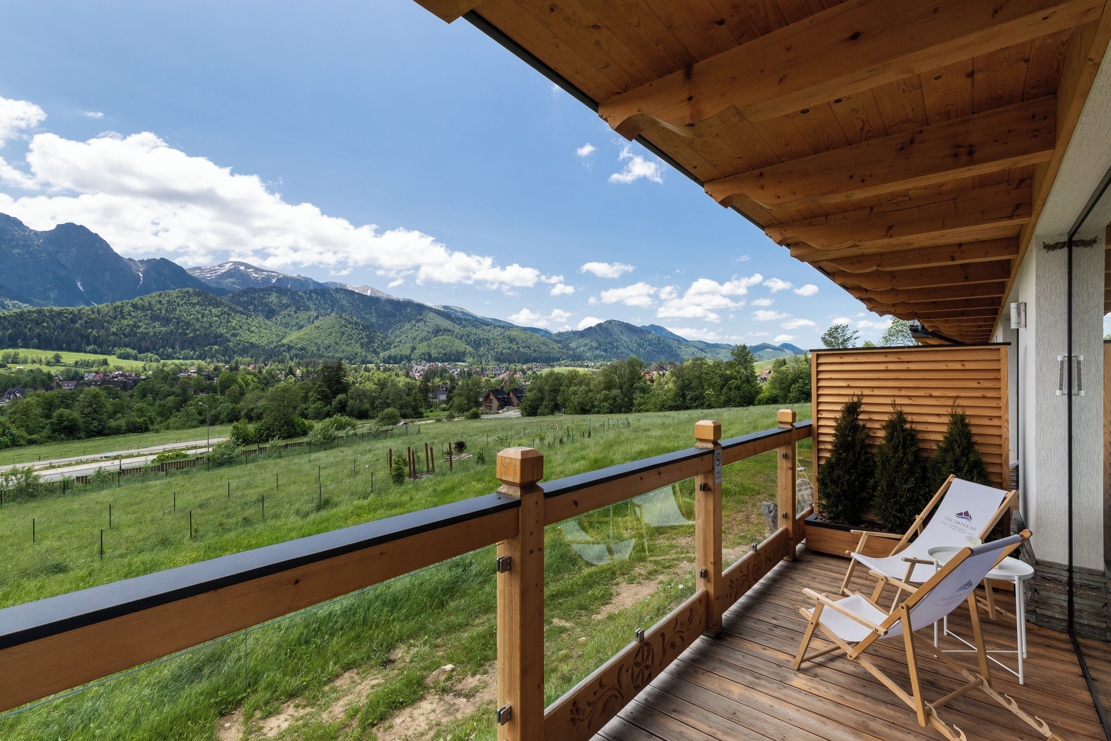 A wooden deck with a view of mountains and a green landscape.