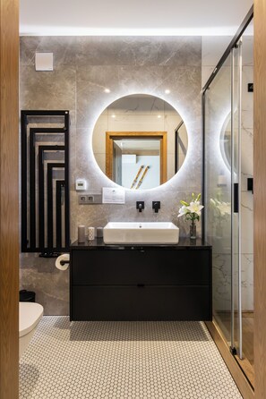 A modern bathroom with a large mirror, a black vanity, and a glass shower enclosure. - IJG Imperial Apartamenty Szymaszkowa (Zakopane)