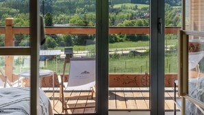 A bedroom with a large sliding glass door leading to a balcony with a mountain view. - IJG Imperial Apartamenty Szymaszkowa (Zakopane)