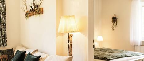 Una habitación acogedora con cama, una silla, una lámpara y un reloj de pared.