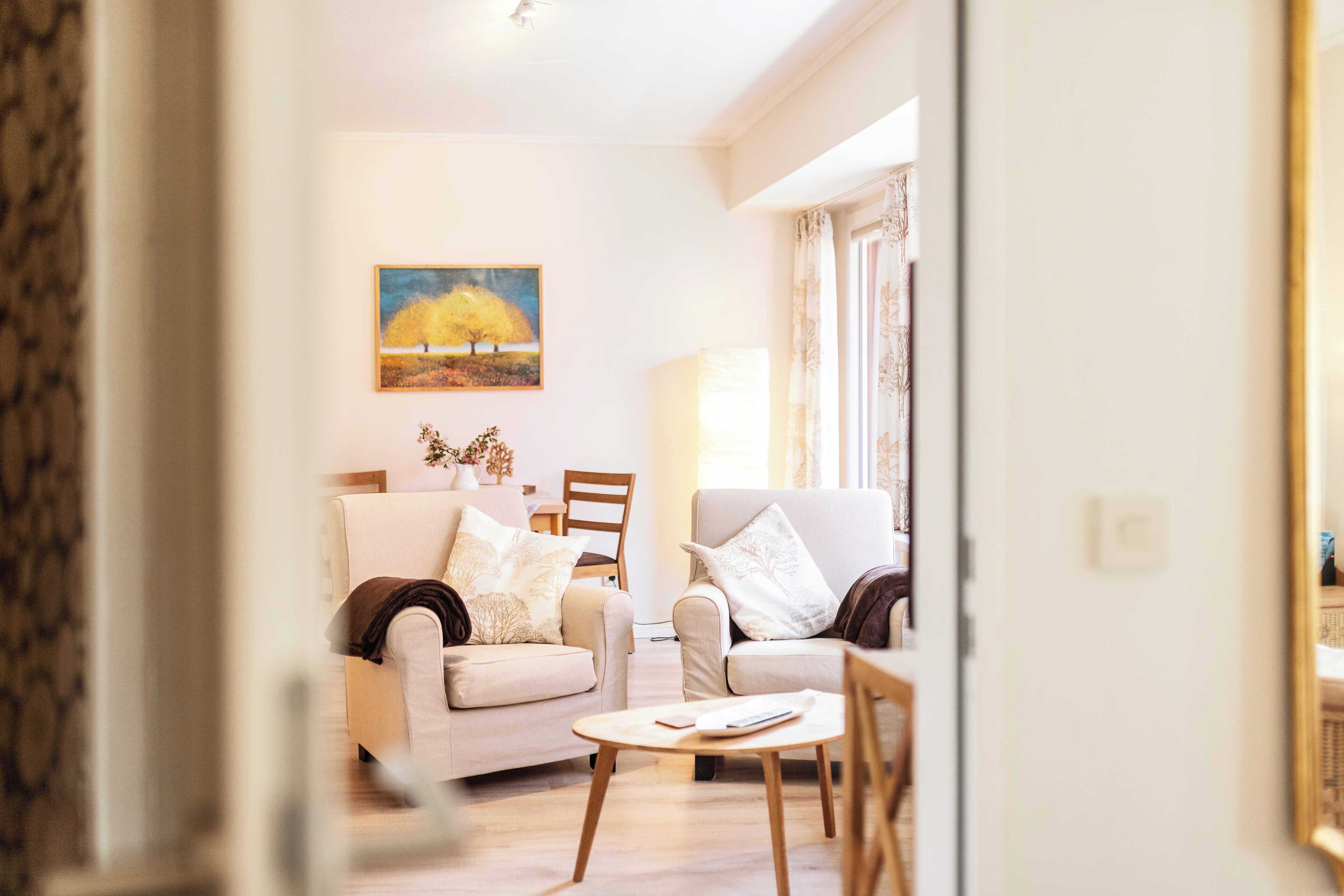 Una sala de estar con dos sofás, una mesa de centro y un cuadro en la pared.