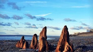A rocky beach with tall, reddish-brown rock formations. - Spacious Modern Apartment with Sea Views in Prime Beachside Location (Westward Ho!)