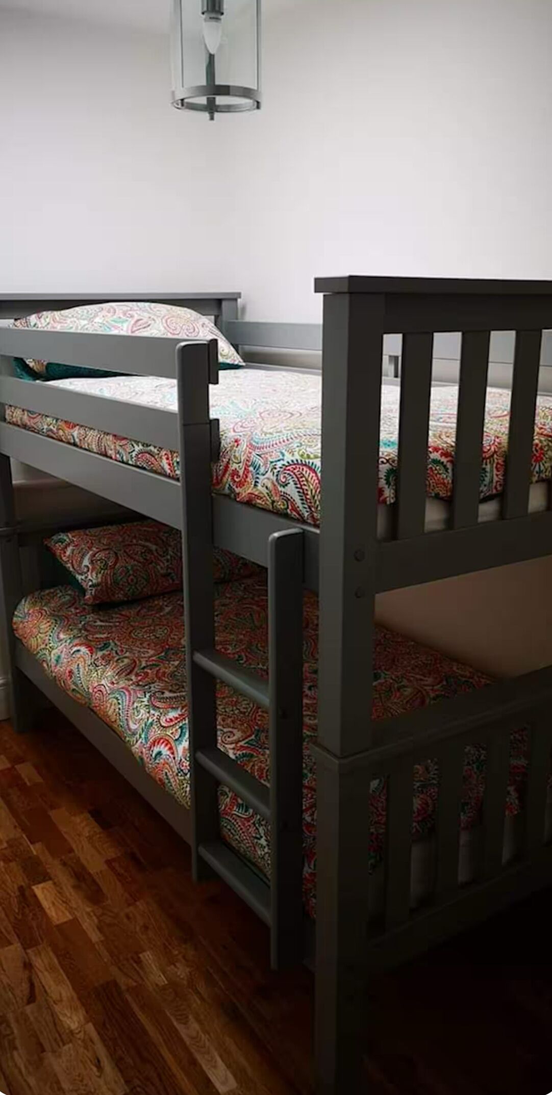 A bunk bed with a wooden frame and patterned bedding.