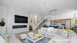Ein modernes Wohnzimmer mit Sofa, Couchtisch und einer Treppe, die zur Küche führt.