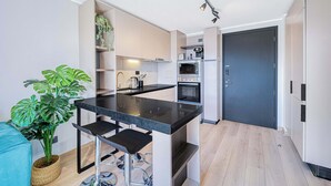 Eine moderne Küche mit schwarzem Arbeitsplatz, Edelstahlgeräten und einem eingebauten Backofen.