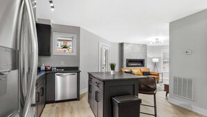 A modern kitchen with stainless steel appliances, a built-in dishwasher, and a central island. - The Lofts of Downtown 540 N 2nd St, #207 (Clarksville)