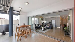 Een moderne woonruimte met een eethoek, een bank en een keuken op de achtergrond.