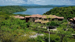 Ein Resort mit mehreren Gebäuden, umgeben von üppiger Vegetation und einem See.