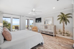 A bedroom with a large bed, a ceiling fan, a dresser, a TV, and a view of the ocean through large windows. - NEW Listing!!! Needle Rush Point C26 - Beachfront View - NO HASSLE CHECK OUT (Perdido Key)
