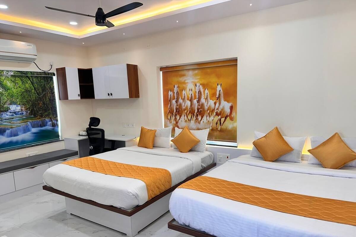 Una habitación de hotel moderna con dos camas, un escritorio y un ventanal grande.