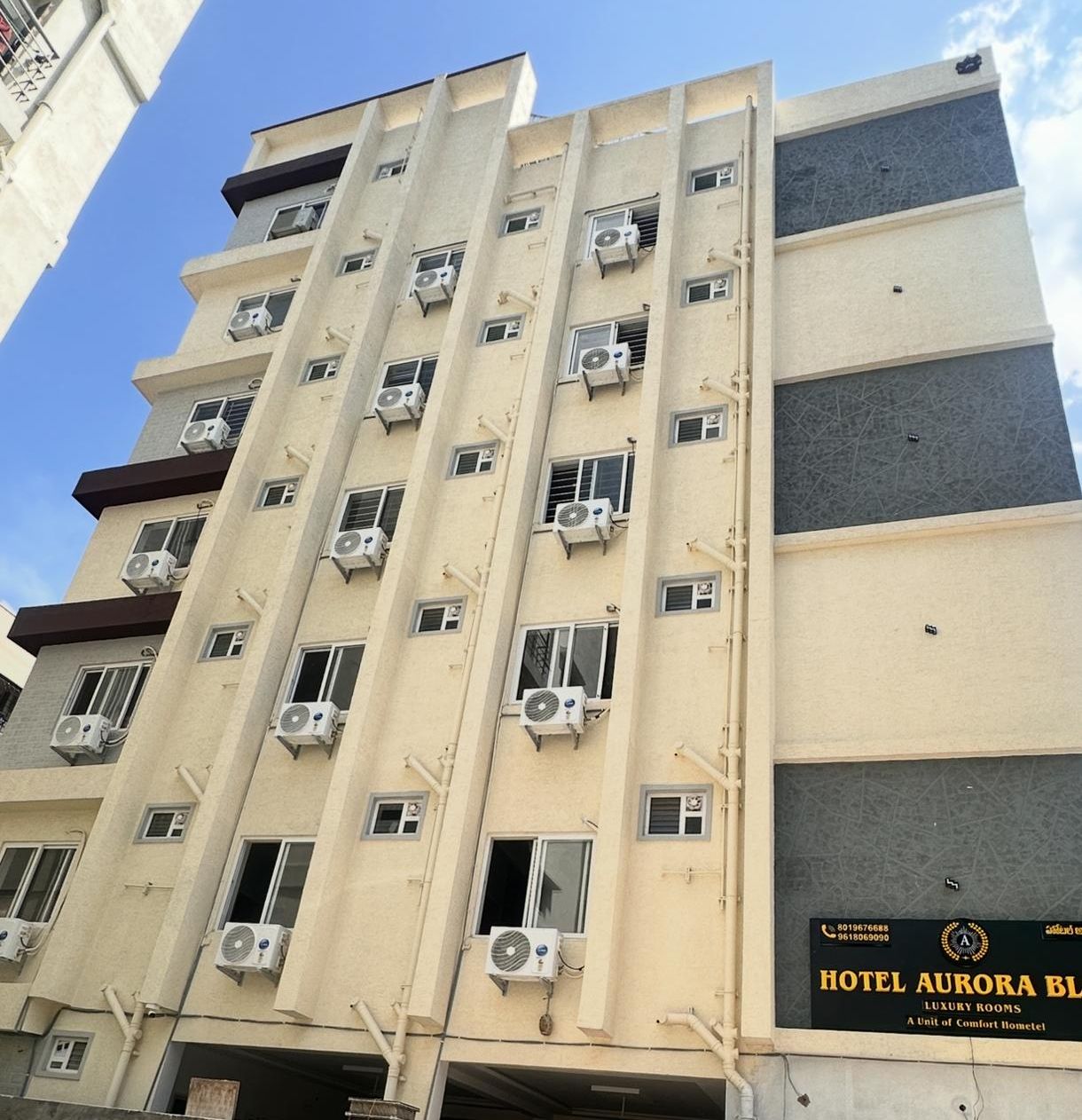 Un hotel de varios pisos con numerosas unidades de aire acondicionado en su fachada.