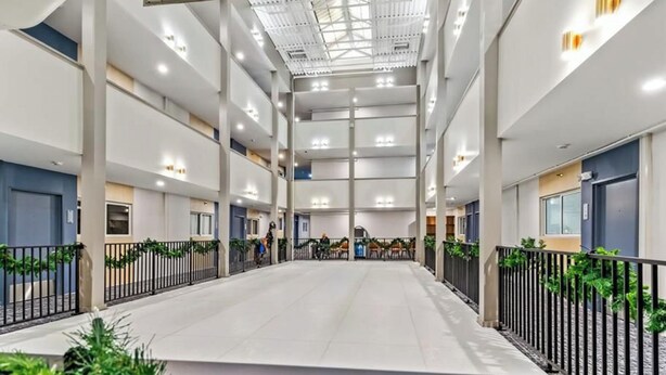 A spacious indoor area with a high ceiling, multiple levels, and a central open space.