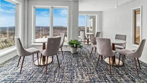 A modern conference room with a panoramic view, large windows, and a patterned carpet.