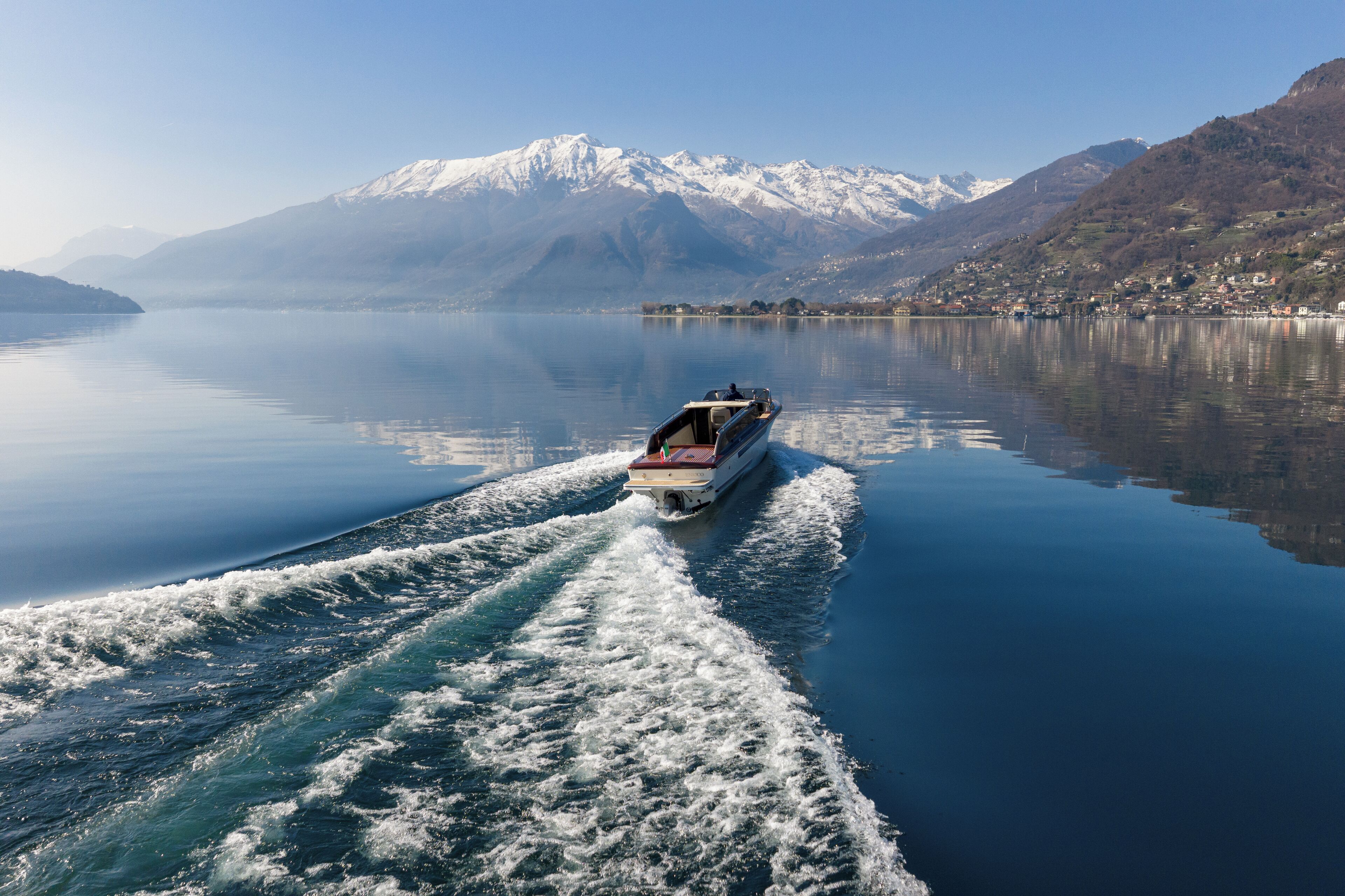 A boat on a calm lake with mountains in the background.